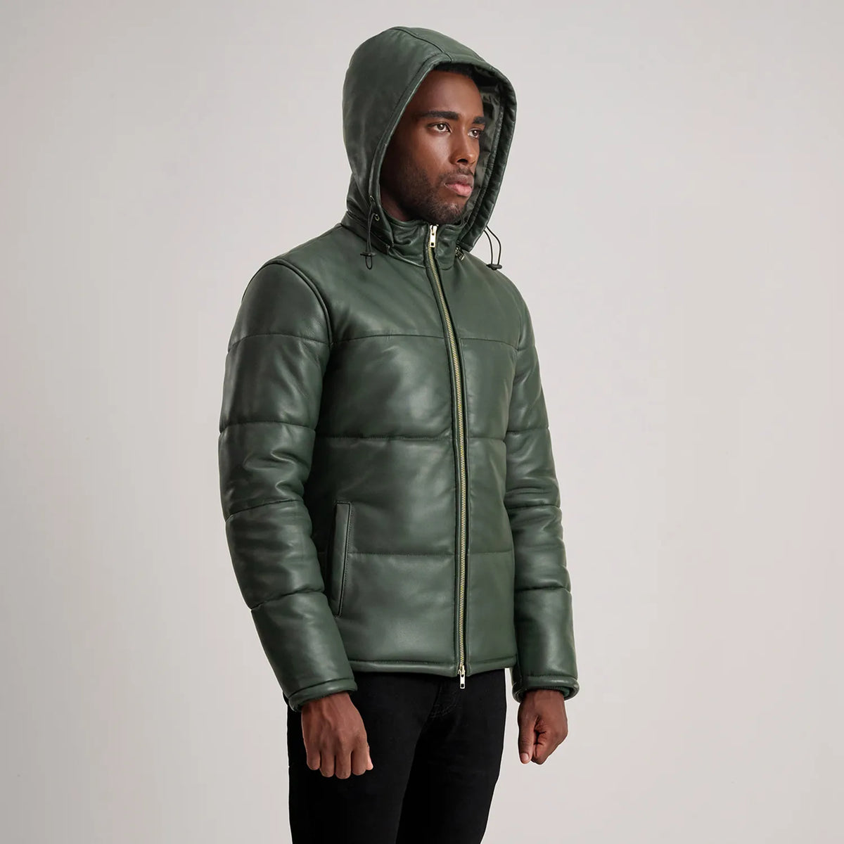 
Perspectiva del modelo vistiendo Gordon Tan Hooded Leather Puffer Jacket en modelo con caída natural bajo luz de día